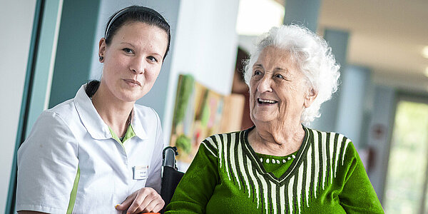 Mitarbeiterin in der Pflege mit Patientin