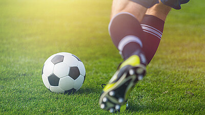 Fußballspieler kickt Ball