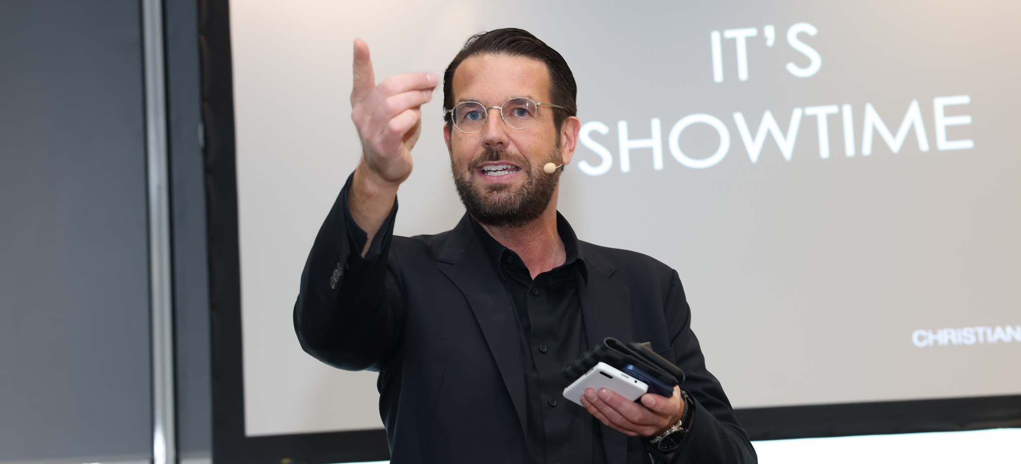 Christian Lindemann Bühne Christian Lindemann steht auf Bühne vor Schild mit der Beschriftung "It's showtime!"
