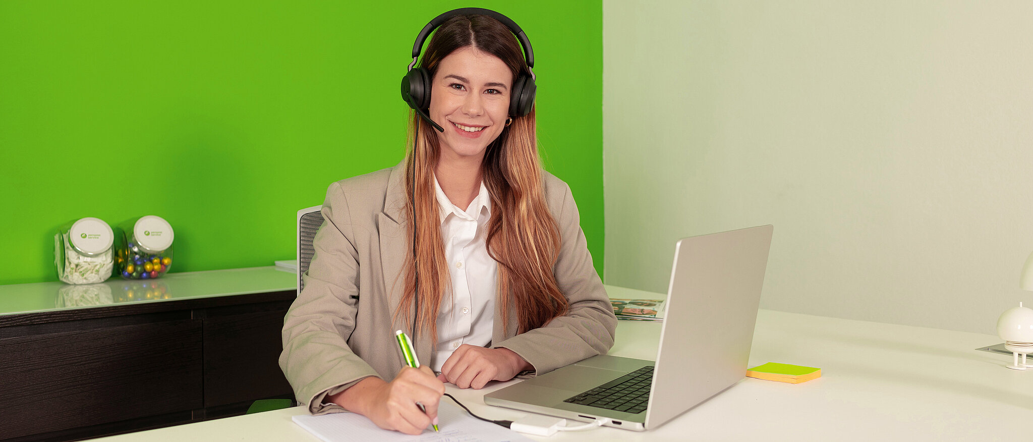 Mitarbeiterin persona service Spanien am Laptop mit Headset