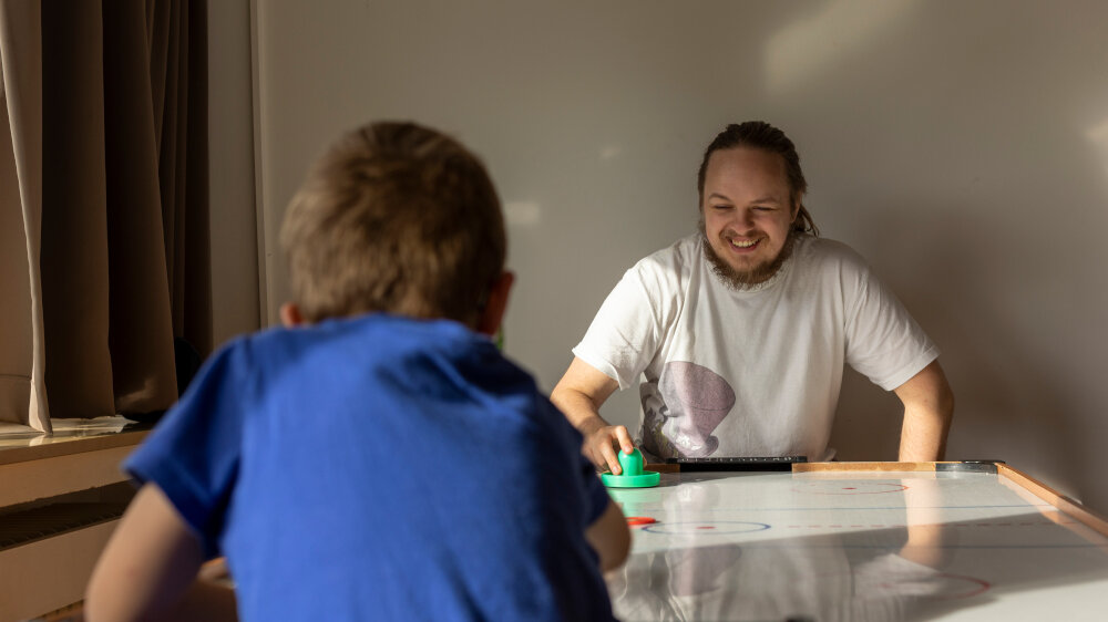 Auszubildender persona service spielt mit Kind in SOS-Kinderdorf